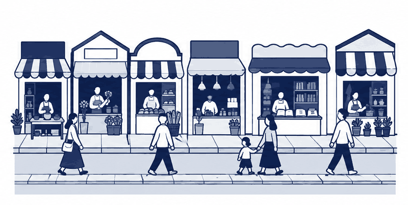 店が6軒ならび、通りを何人もの人が店から店へ歩いている